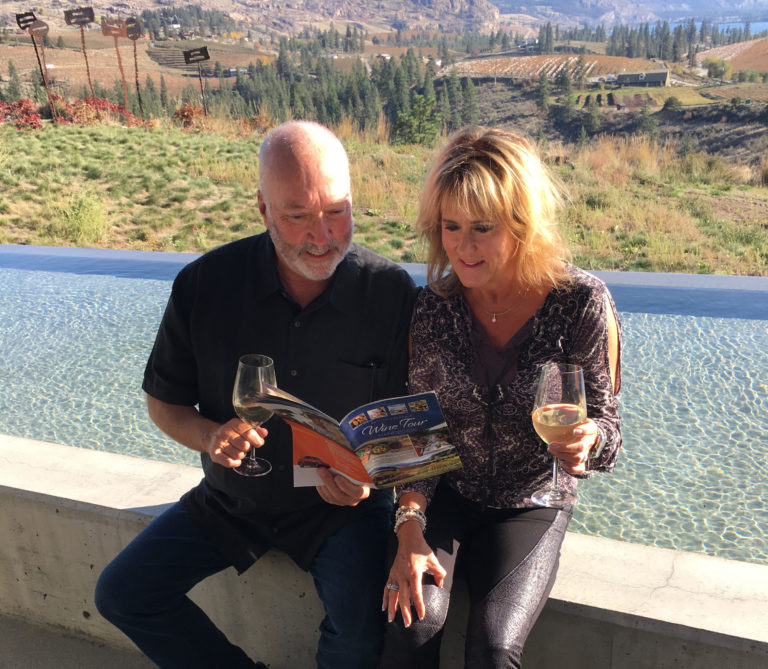 couple on a wine tour reading The BC Wine Tour Handbook