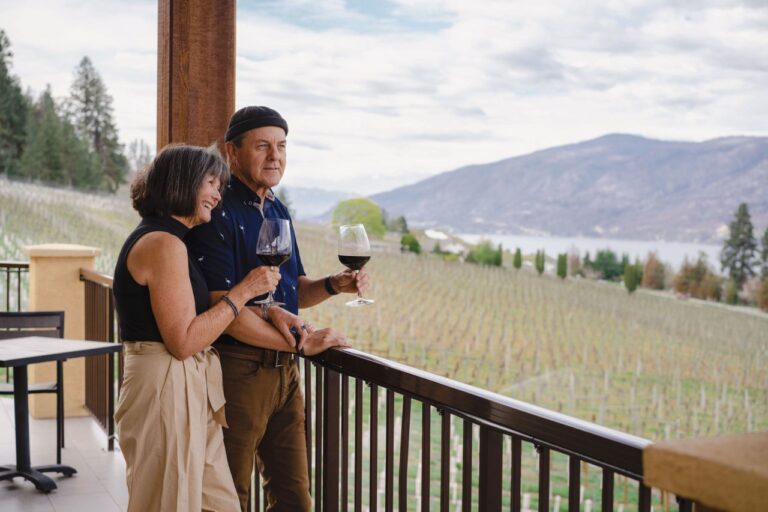 couples wine tasting on the patio overlooking Okanagan Lake