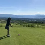 golfer on tee box overlooking city and lake views