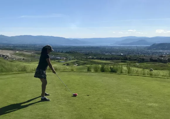 golfer on tee box overlooking city and lake views